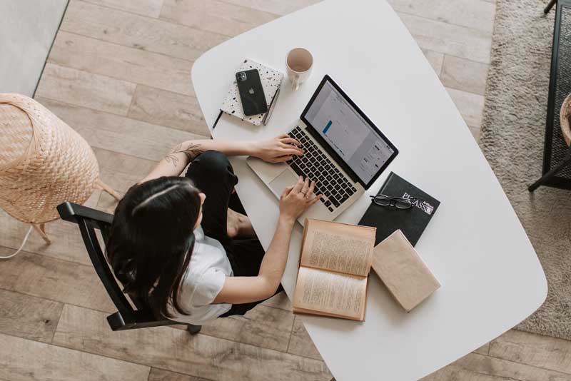 mujer escribiendo en su computador