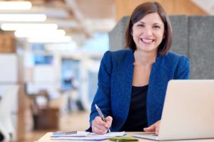 mujer sonriendo sentada en su escritorio