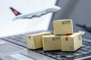 cajas de cartón sobre un computador y una avión de fondo