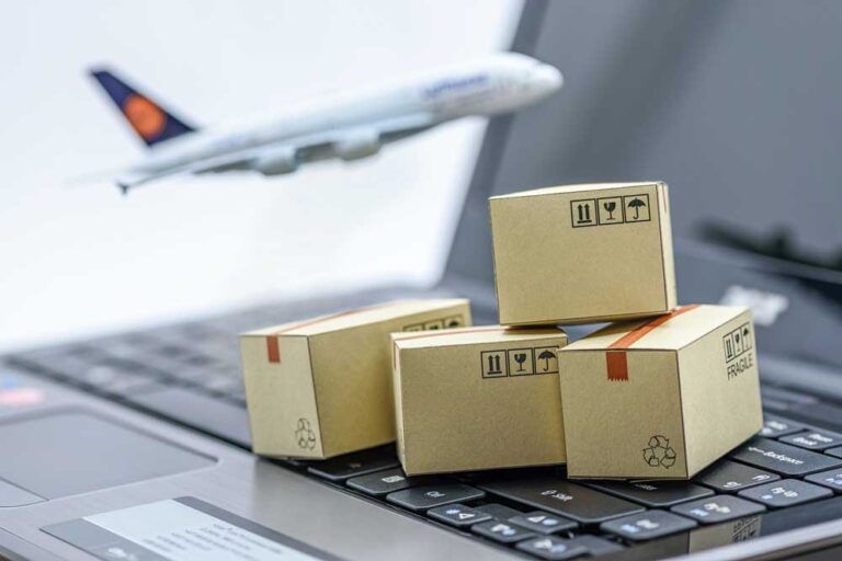 cajas de cartón sobre un computador y una avión de fondo