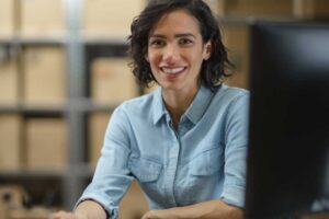 mujer sonriendo apoyada en su escritorio